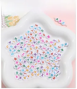 Macro detail of white acrylic letter beads in a star tray for DIY jewelry making