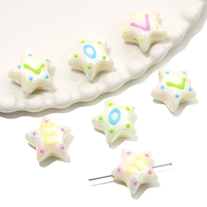 Vue macro de perles en acrylique en forme d'étoile avec lettres LOVE et points colorés pour bijoux