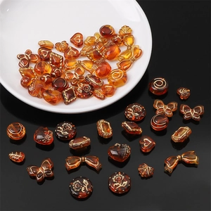 Macro detail of acrylic amber beads with gold accents and vintage patterns for DIY jewelry