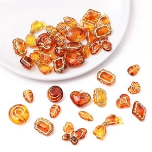 Detailed macro view of assorted amber acrylic beads with vintage gold rim for DIY jewelry