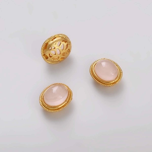 Detalle de piedras rosas ovales engastadas en oro y una cuenta espaciadora filigrana oro