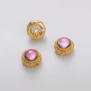 Detalle macro de cuentas espaciadoras doradas con circón púrpura y diseño floral para joyería