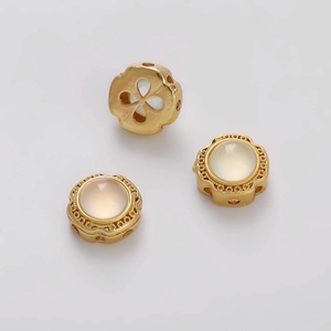 Detalle de cuentas de cobre dorado con incrustación de ópalo para creación de joyería