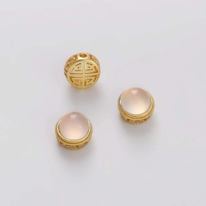 Detalle de cuentas huecas doradas y gemas rosa translúcidas para crear joyería