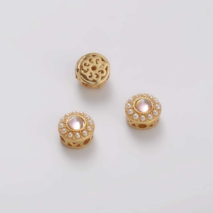 Vista detallada de cuentas doradas con gema rosa y borde de perlas para joyería DIY