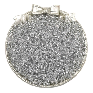 Macro shot of transparent glass seed beads for DIY jewelry making in a silver vintage tray