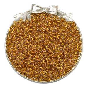 Macro detail of transparent golden glass seed beads for DIY handmade jewelry crafts