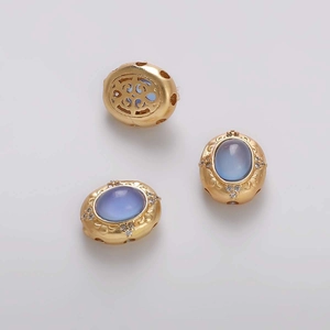 Detalle de tres cuentas doradas ovaladas vintage con piedras azul claro para joyas DIY