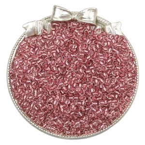 Macro shot of pink silver-lined glass seed beads for DIY jewelry making in a silver tray