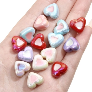 Perles de cœur acryliques irisées pour bijoux DIY présentées dans la paume de la main