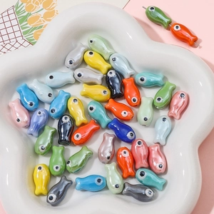 Macro shot of colorful ceramic fish beads with glossy glaze for DIY jewelry making