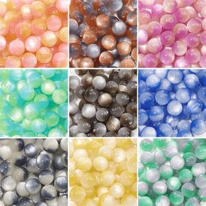 Macro view showing nine colors of round resin cat eye beads for DIY jewelry making