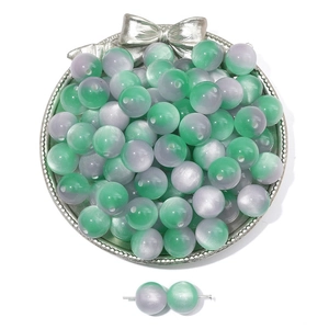 Macro detail of dual-tone cat-eye resin beads in silver tray for DIY jewelry making