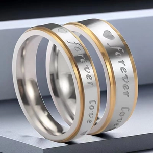 Detail of titanium steel couple rings with "Forever Love" engraving and heart symbol.