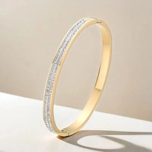 Vista dettagliata di un elegante bracciale in acciaio al titanio oro con due file di cristalli