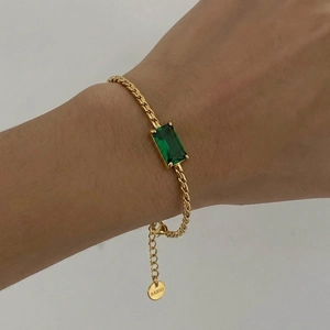 Elegant gold woven chain bracelet featuring a square emerald green zircon gemstone on wrist