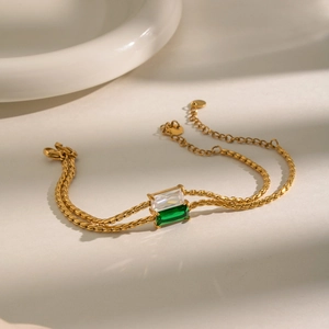 Gold double-layered twisted chain bracelet with emerald and white rectangular zircons