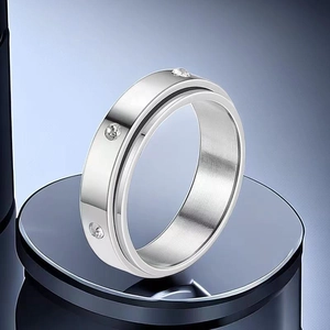 Close-up detail of a silver stainless steel spinner ring with embedded crystals.