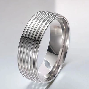 Detailaufnahme eines silbernen Edelstahlrings mit minimalistischem Rillenmuster