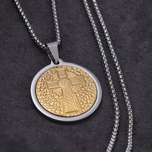 Macro detail of silver and gold Celtic cross pendant showing metallic texture and round chain