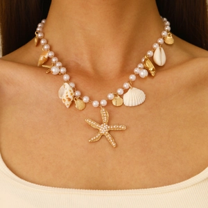 Bohemian seashell necklace with faux pearls and gold starfish charms on a model
