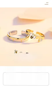 Macro shot of S925 silver bee couple rings with gold drip design and zircon stones