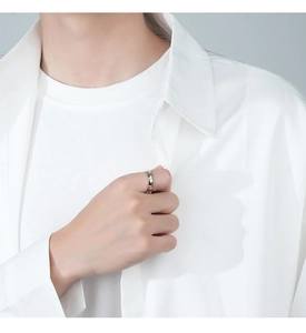 Male model wearing minimalist silver and gold two-tone bee ring on index finger