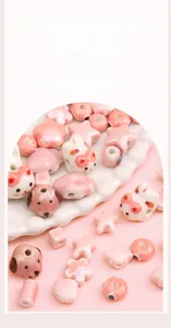 Detailed view of pink ceramic beads in cat, flower and star shapes for DIY jewelry making