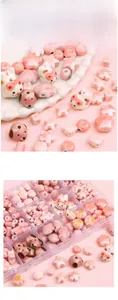 Detailed view of pink ceramic beads in cat and flower shapes with a grid storage box