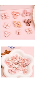 Close-up of pink ceramic DIY beads in star, flower, and animal shapes for jewelry