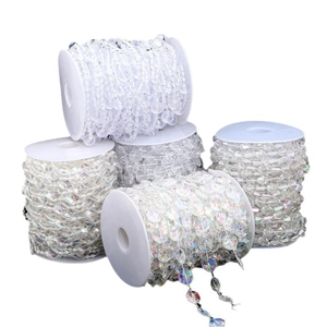 Five rolls of iridescent acrylic bead chains on white spools for wedding and DIY crafts