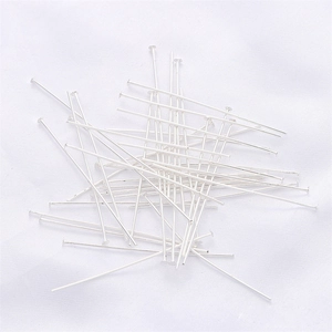 Macro shot of silver-colored flat head pins and T-pins for DIY jewelry making material