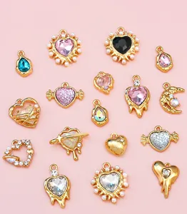 Flat lay of diverse DIY jewelry charms including hearts, moons, and stars with rhinestones