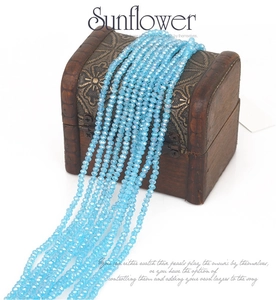 Macro detail of 2mm light blue faceted crystal beads arranged on a small wooden chest