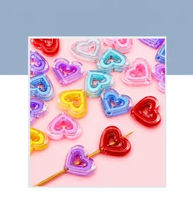 Vue macro de perles en cœur acryliques transparentes colorées avec centre creux pour DIY