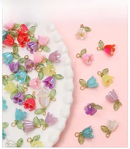 Detailed macro view of colorful acrylic lily of the valley beads with green leaves and rings