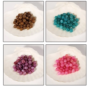 Détail de perles en acrylique colorées dans des coquillages pour bijoux DIY