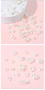 Detailed view of pearl white acrylic beads in various geometric shapes for DIY jewelry