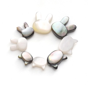 Vue détaillée de perles en nacre naturelle en forme de chat et lapin pour bijoux DIY