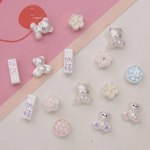 Macro shot of S925 silver teddy bear and flower charms with pink enamel details