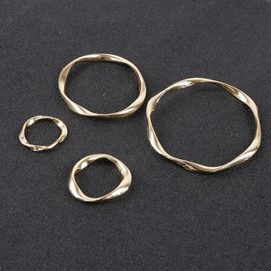 Detailed view of four different sized golden twisted geometric circles for DIY earrings
