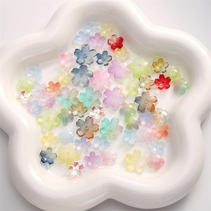 Macro shot of colorful cherry blossom glass beads for DIY jewelry making in a white plate