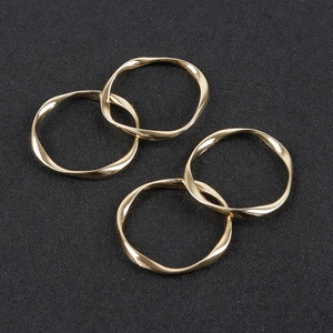 Macro view of four twisted gold alloy geometric rings for DIY earring jewelry making