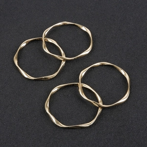 Detailed view of four golden irregular wavy alloy rings for DIY jewelry making accessories
