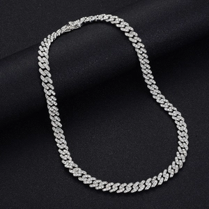 Gros plan d'un collier chaîne cubaine serti de zircons sur un présentoir noir
