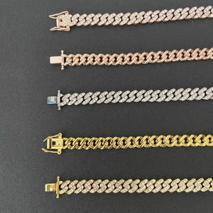 Détails de plusieurs chaînes à maillons cubains en or, argent et or rose avec strass pavés