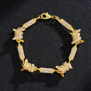 Macro-opname van gouden hiphop-armband met diamantgezette prikkeldraadschakels en sluiting