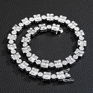 Détail d'une chaîne cubaine argentée 12mm avec cristaux sur fond de cuir noir texturé