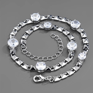 Macro shot of silver-toned pyramid link chain necklace with sparkling zircon gemstones
