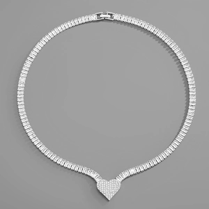 Macro shot of a silver-toned tennis chain with rectangular zircon and heart-shaped pendant